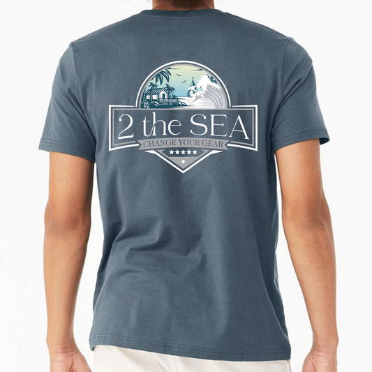 Back view of 2theSEA BEACH HOUSE T-Shirt in Slate Blue featuring the large Change Your Gear coastal graphic with beach house, palms, waves, and shoreline.
