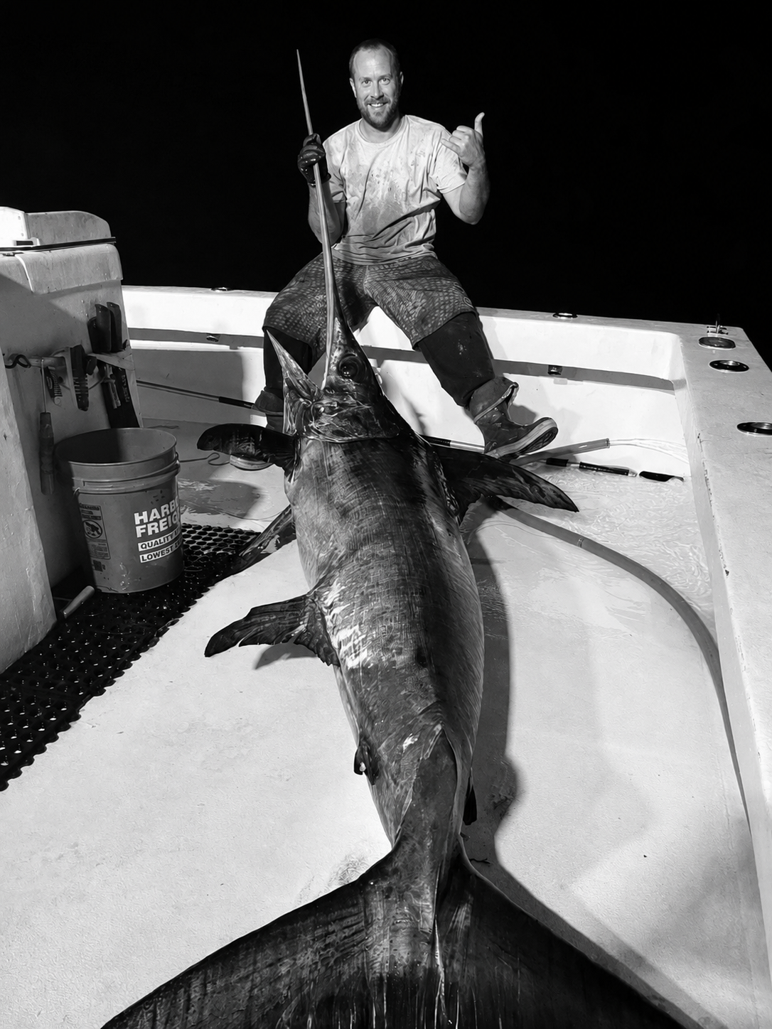 offshore boat in Florida at night with a large swordfish stretched across the deck