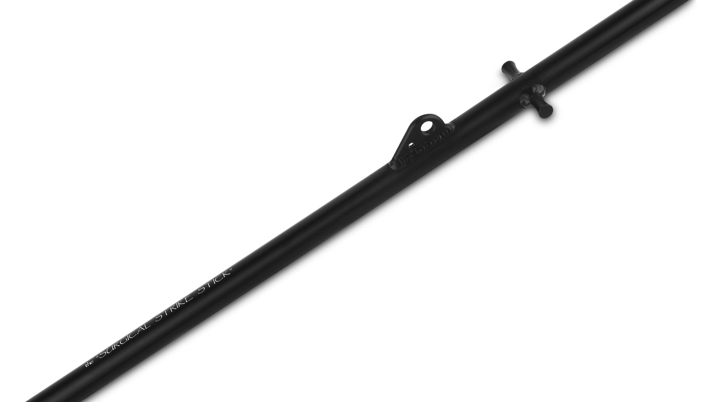Close-up of the Surgical Strike Stick harpoon showing the integrated Throwing Finger Grip and Rigging Retrieval Fin on the anodized black shaft