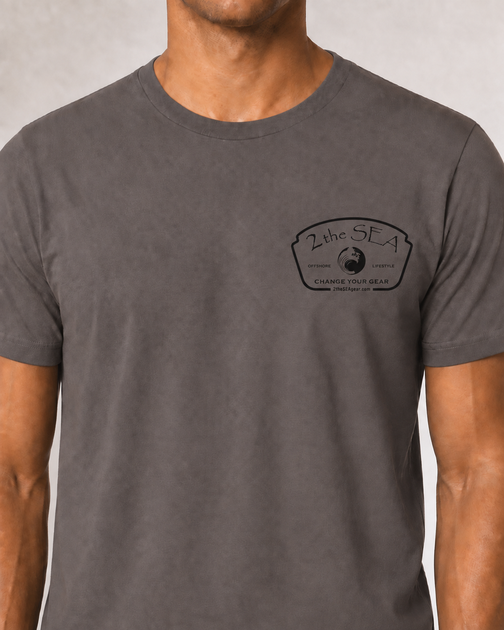 Close-up front view of The Mark Pebble Brown 2theSEA T-shirt showing the black Change Your Gear badge graphic on the left chest.
