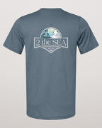 Studio back view of the Shore House Slate Blue 2theSEA T-shirt featuring the large house, palm and wave graphic centered on the back.