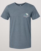 Studio front view of the Shore House Slate Blue 2theSEA T-shirt featuring the coastal house, palm and wave graphic on the left chest.