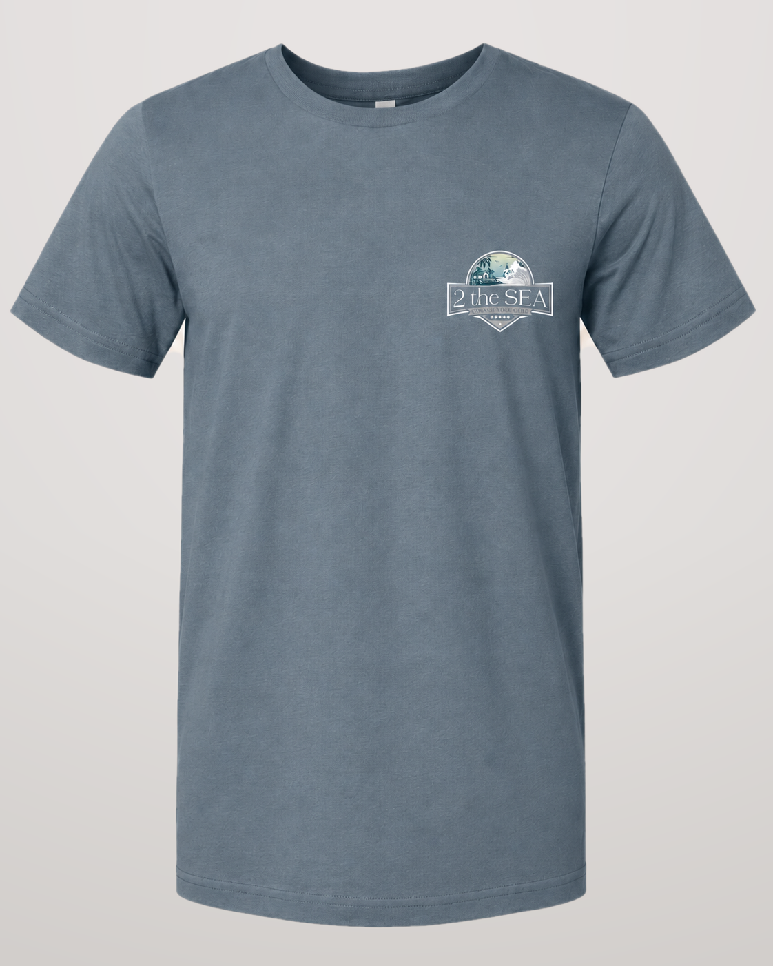 Studio front view of the Shore House Slate Blue 2theSEA T-shirt featuring the coastal house, palm and wave graphic on the left chest.