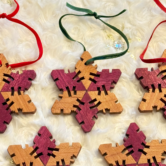Wooden snowflake ornaments with ribbons on a textured white surface